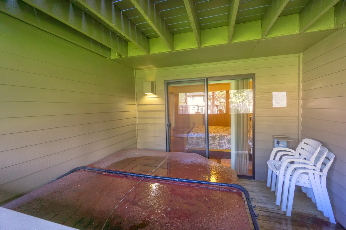 This image features a serene interior scene with a private hot tub near a sliding glass door and two white chairs, creating a perfect space for relaxation and unwinding. The natural light streaming in suggests a connection to the outdoors, while the hot tub is the focal point, inviting guests to soak after an adventurous day.